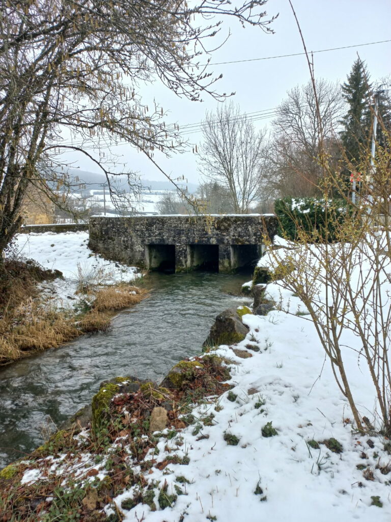 Pont au dessus de la rivière sous la neige